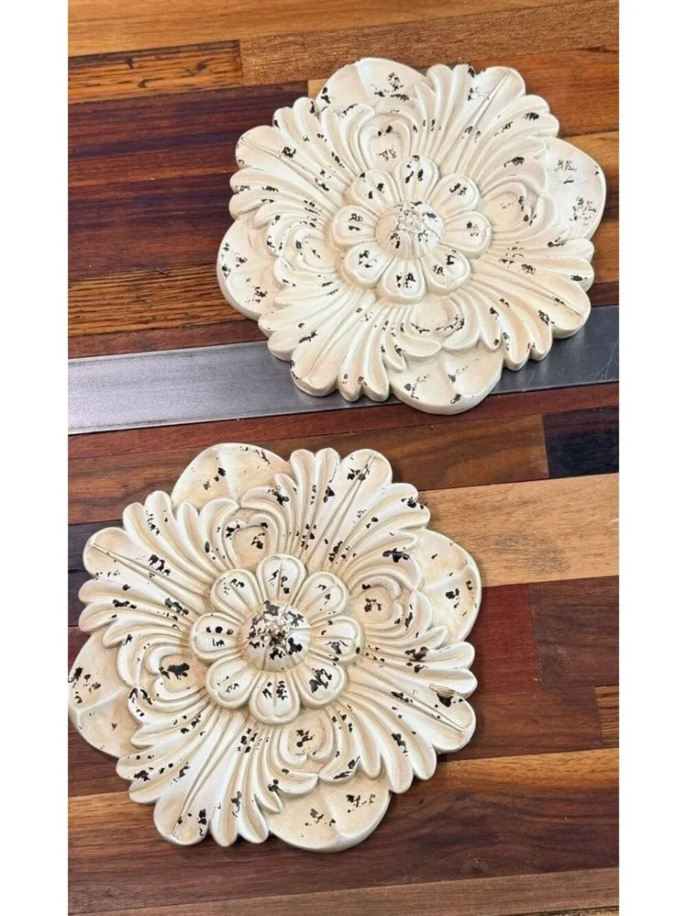 Pair of distressed white floral wall medallions designed with a vintage, shabby